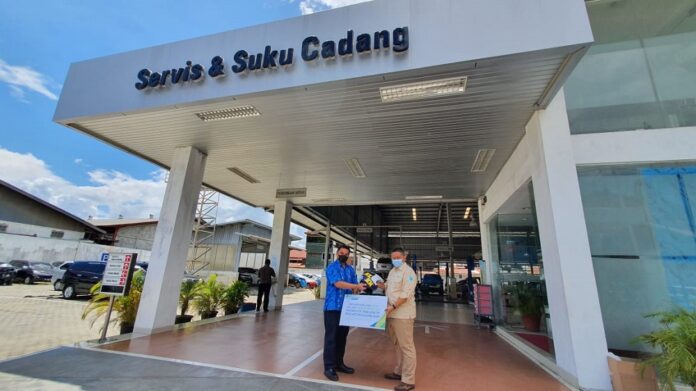 Kepala BPJS Ketenagakerjaan Cabang Papua Jayapura, I Ketut Arja Leksana berfoto usai penyerahan helm.(Istimewa)
