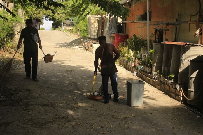 BERSIHKAN-Petugas kebersihan lapangan Kelurahan Asano, Distrik Abepura Kota Jayapura sedang melakukan aktivitasnya guna membersihkan sampah di setiap lorong di Tanah Hitam, Kelurahan Asano, Jumat (14/1).(Yudhi/Bintang Papua)